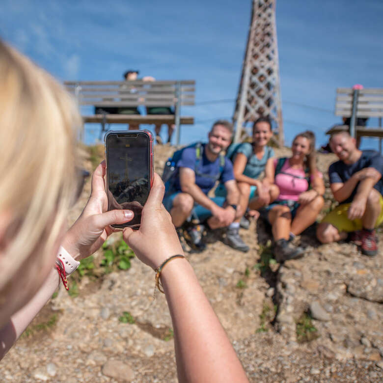 Frau macht ein Bild von einer Gruppe auf dem Hochgrat im Allgäu.