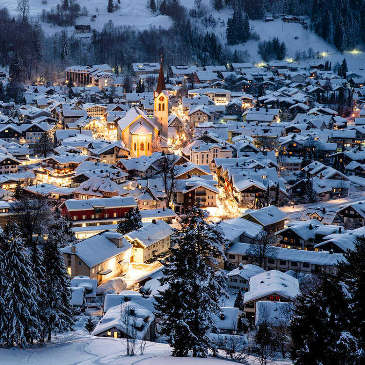 Beleuchtetes Ortszentrum von Oberstaufen bei Nacht.