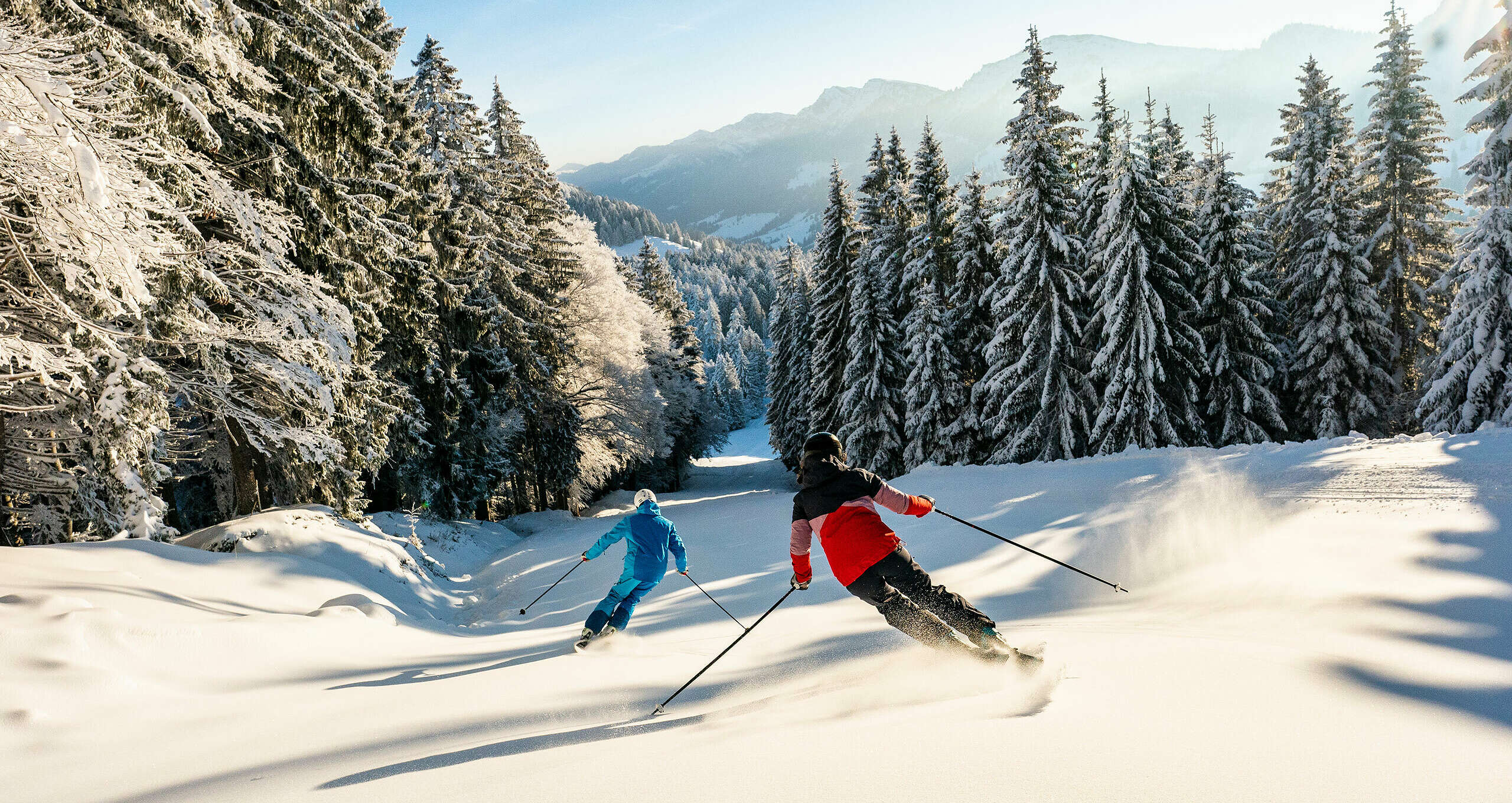 Skifahren auf den Pisten in Oberstaufen mit Blick auf die Allgäuer Berge.