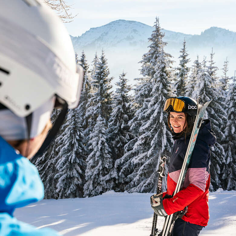 Zwei Skifahrer in Steibis an einem sonnigen Wintertag mit der Nagelfluhkette im Hintergrund