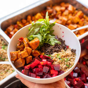 Bunte Bowl mit Süßkartoffeln, Roter Bete, Quinoa, Linsen und Rucola vor einem Buffet bei den Achtsamkeitstagen in Oberstaufen im Allgäu