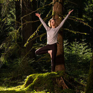 Frau in Yoga Position Baum im Wald