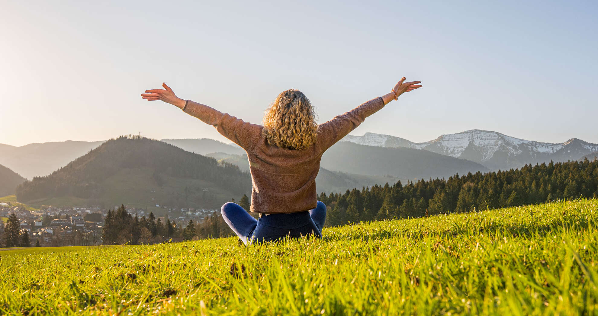 Guten Morgen Frau entspannt in der Natur mit Weitblick auf Oberstaufen und die umliegenden Berge