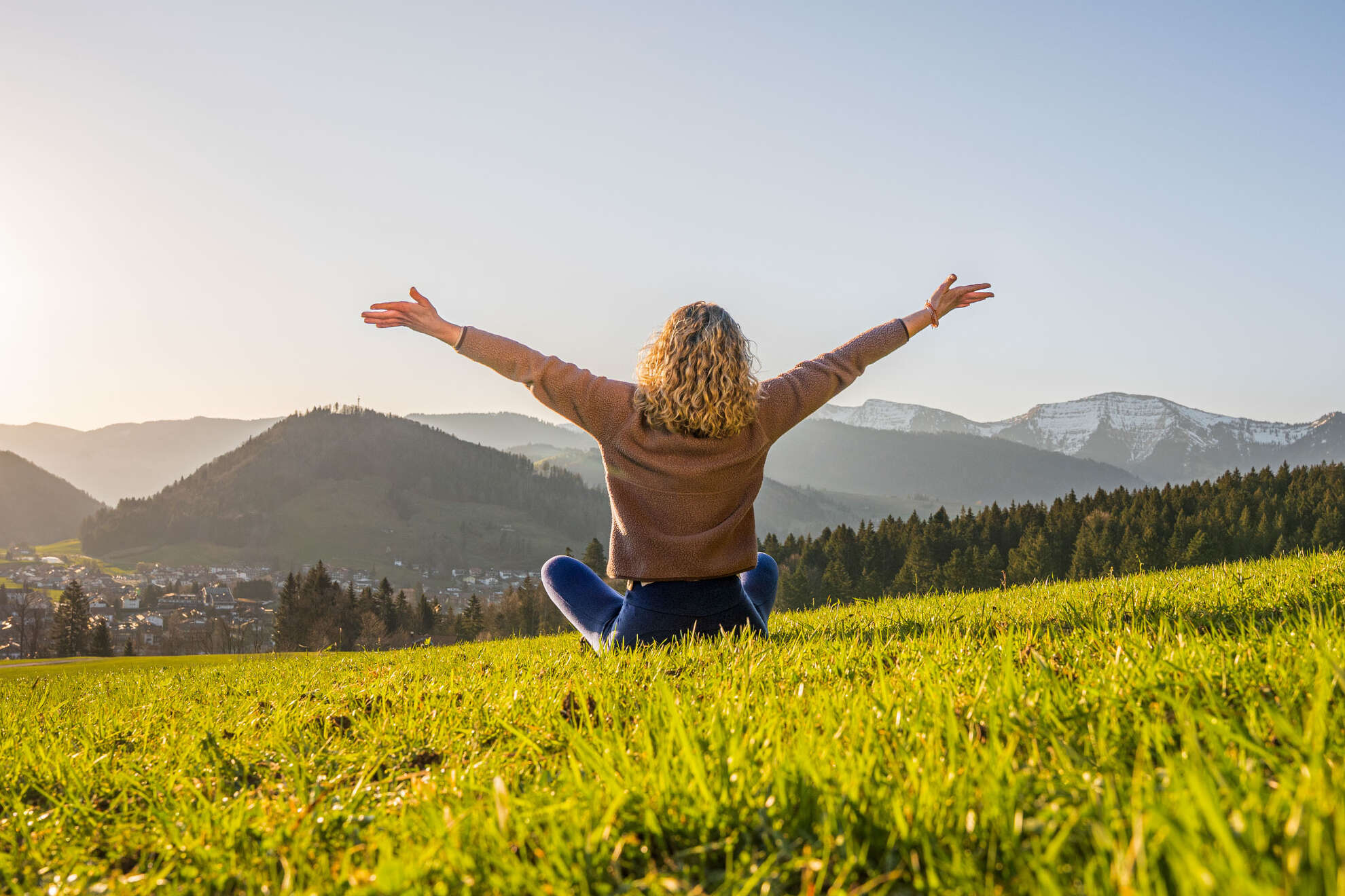 Guten Morgen Frau entspannt in der Natur mit Weitblick auf Oberstaufen und die umliegenden Berge