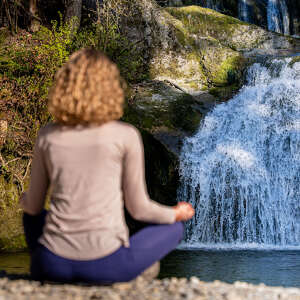 Frau im Lotus-Sitz an den Eibele-Wasserfällen
