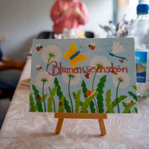 Tischkarte mit der Aufschrift „Blumenwiesenschön“ und Blumenmotiven bei einem Workshop des Oberstaufener Weitblick