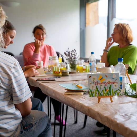 Teilnehmerinnen sitzen bei einem Naturkosmetik-Workshop am Tisch beim Oberstaufener Weitblick