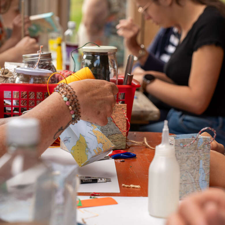 Ein Junge bastelt mit alten Landkarten beim Upcycling-Angebot des Oberstaufener Weitblicks
