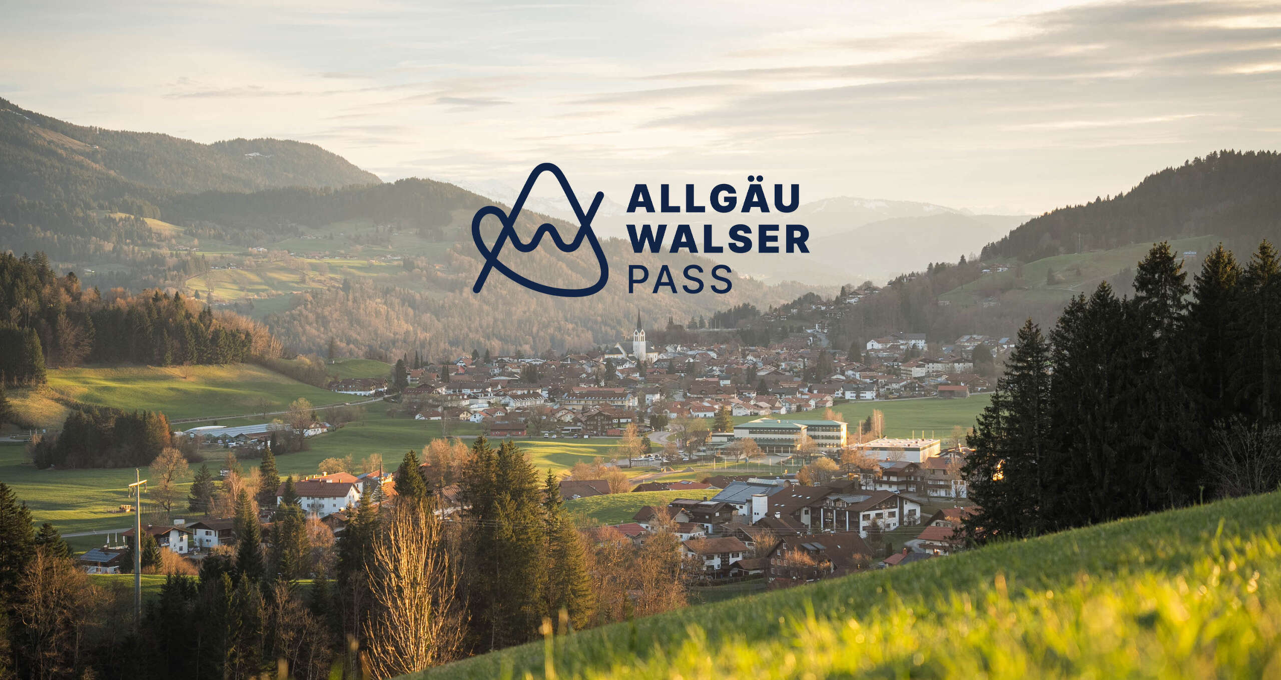 Logo Allgäu Walser Pass mit Ortsansicht Oberstaufen im Frühling