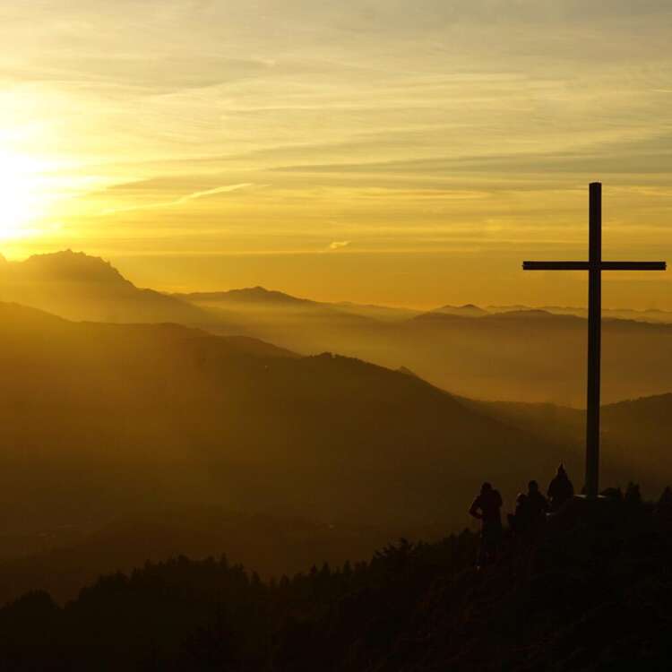 Allgäuer Berge mit Gipfelkreuz im Sonnenuntergang