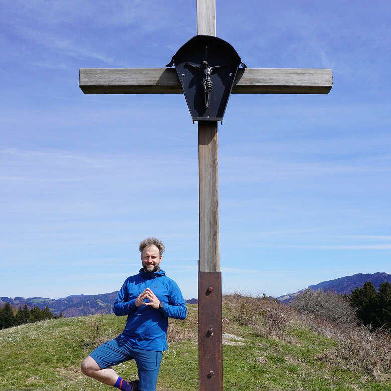 Ein Mann macht Yoga neben in den Allgäuer Bergen.