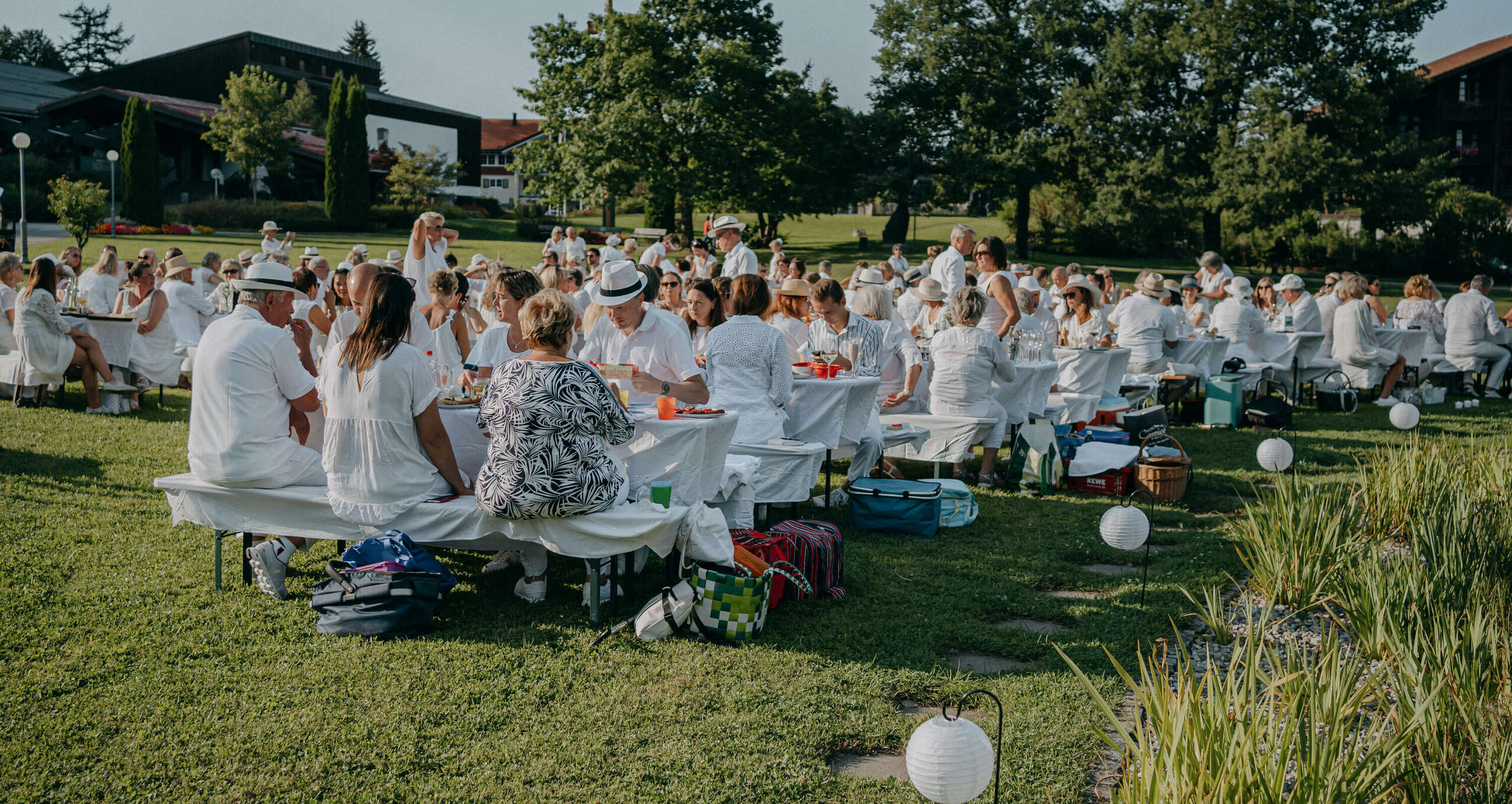 Menschen picknicken in weißer Kleidung im Oberstaufen Park