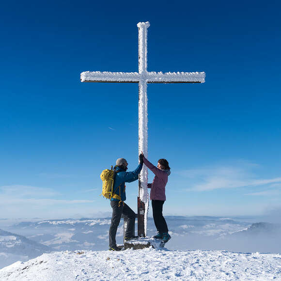 Wanderer schlagen ein am Gipfelkreuz
