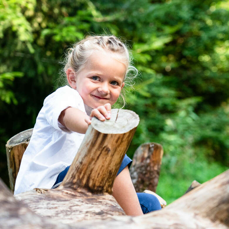 Kind spielt im Wald im Allgäu