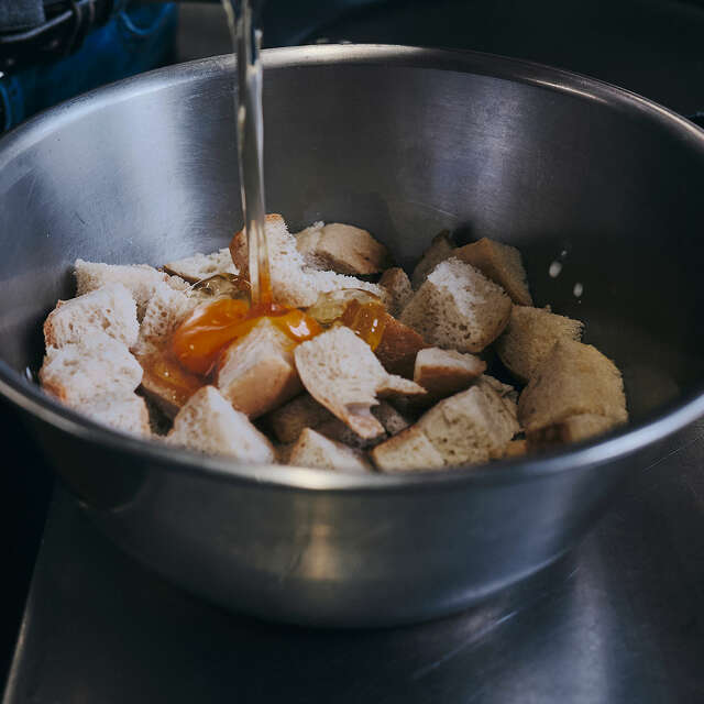Ein Ei wird in die Zutaten des Allgäuer Semmelschmarrns geschlagen.