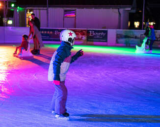 Kinder beim Euslaufen auf dem beleuchteten Eisplatz in Oberstaufen