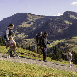 Familie mit Kindern wandert am Imberg bei Ausblick auf das Bergpanorama der Nagelfluhkette