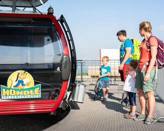Familie am Einstieg in die Gondel der Hündlebahn
