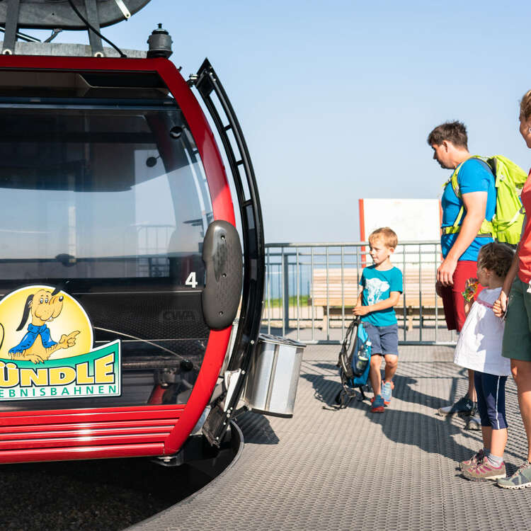 Familie am Einstieg in die Gondel der Hündlebahn