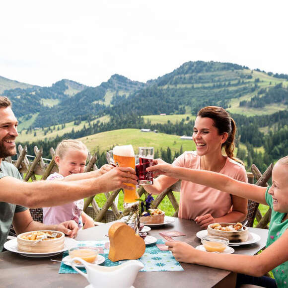 Familie beim Essen und Trinken auf einer Hütte am Imberg mit Bergpanorama von Stebis