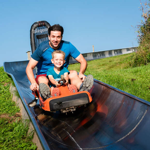 Familie beim Sommerrodeln auf der Bahn am Hündle