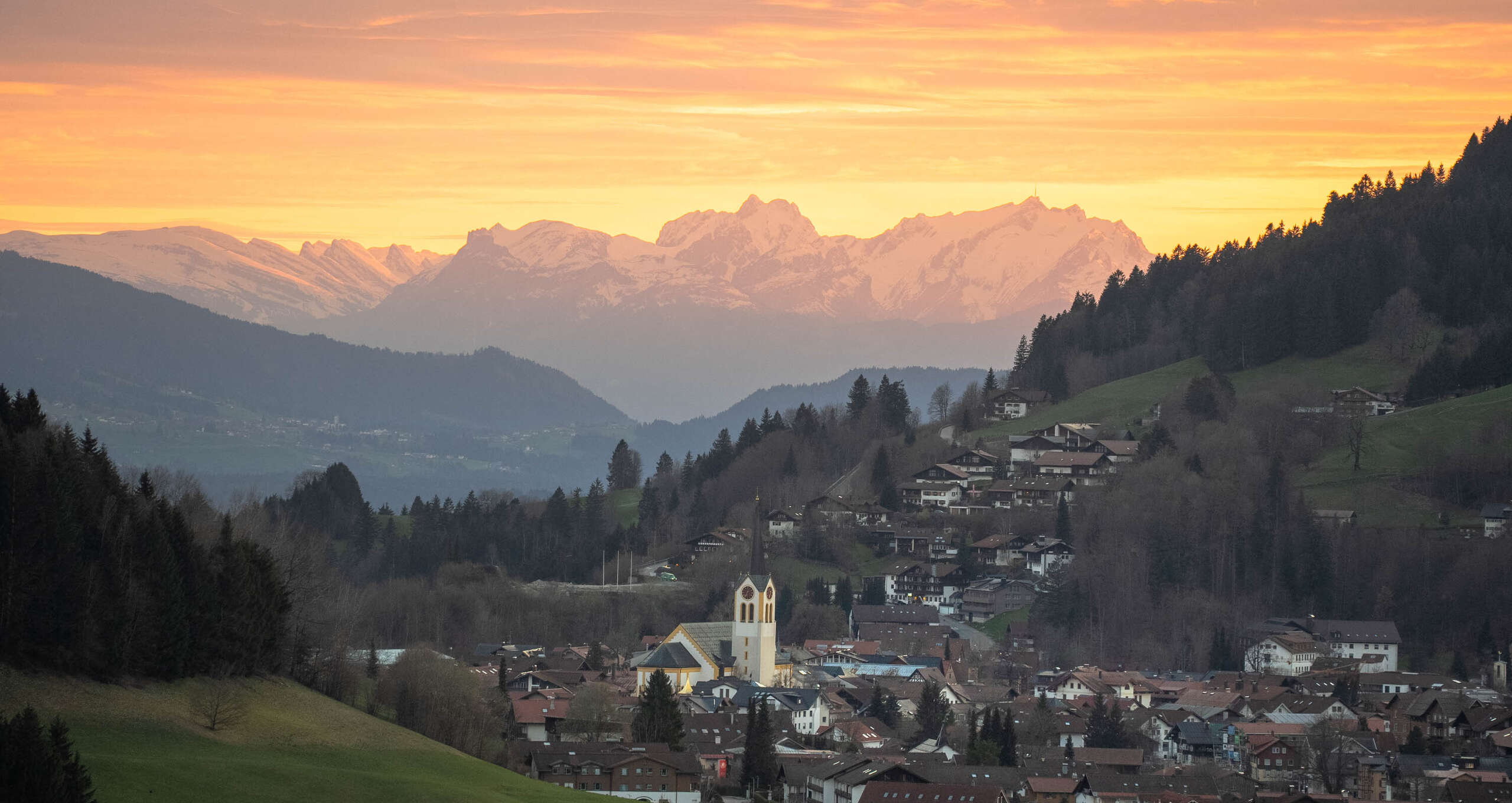 Oberstaufen Ort umgeben von Bergen und Weiblick zum Säntis im Abendrot