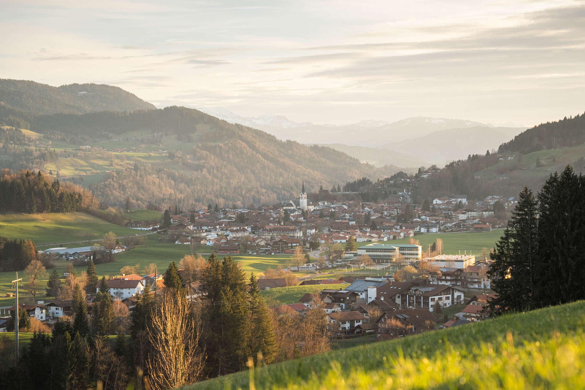 Oberstaufen Ort umgeben von Wiesen und Bergen im Frühling
