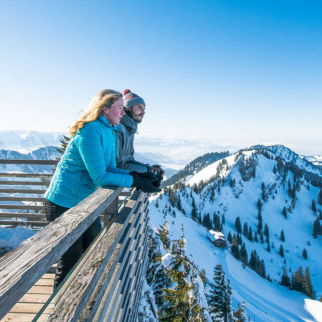 Paar genießt im Winter die Aussicht von der Hochgrat Bergstation