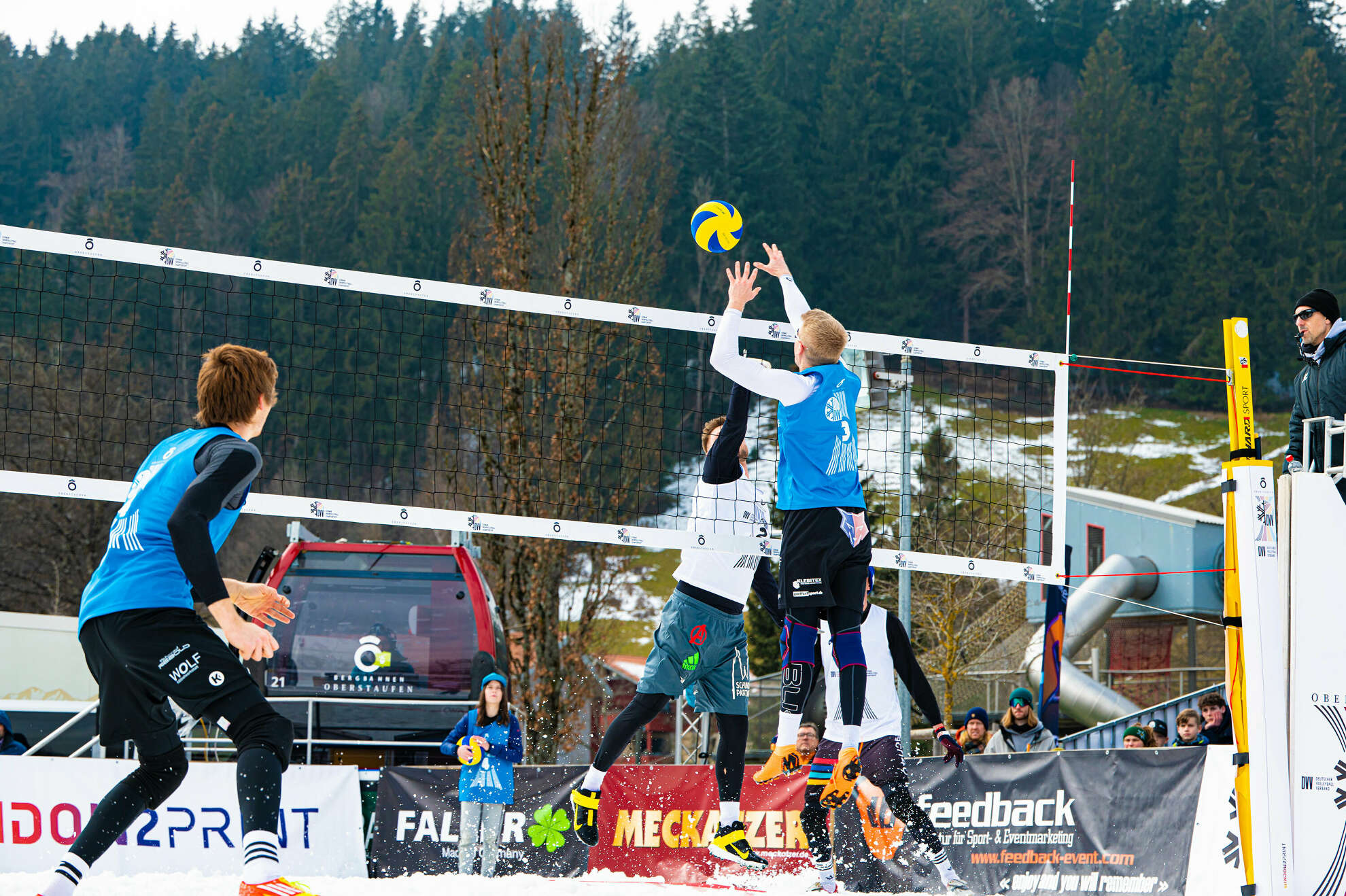 Zwei Spieler kämpfen um den Ball bei der Snow-Volleyball Meisterschaft.