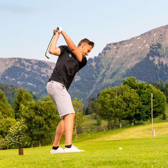 Golfer schlägt auf dem Golfplatz in Steibis ab