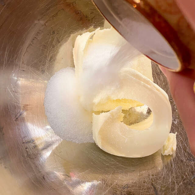 Zucker wird in eine Schüssel mit Butter gegeben.