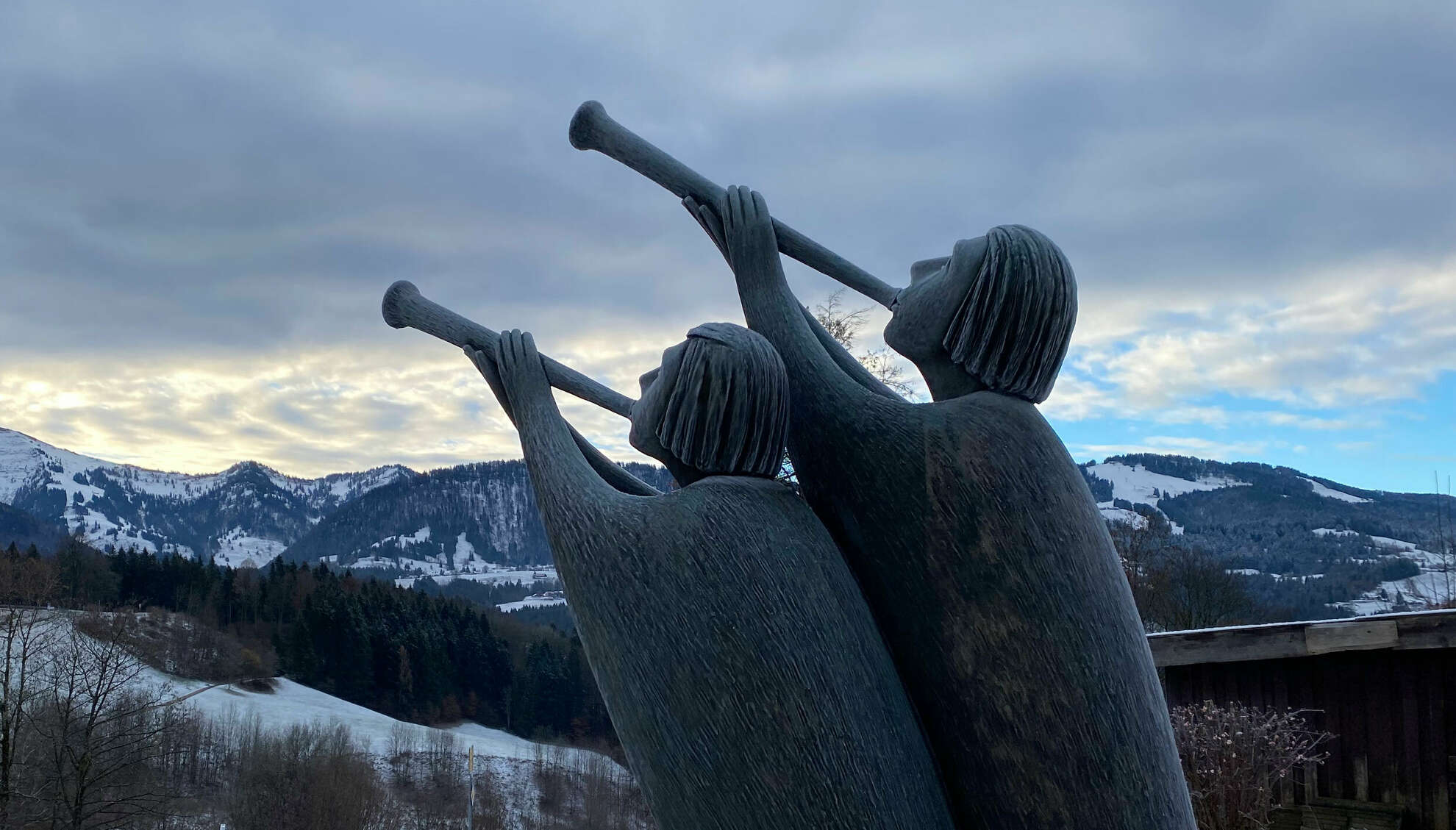 Verschneite Bronzestatuen vor dem Hochgrat in Oberstaufen.