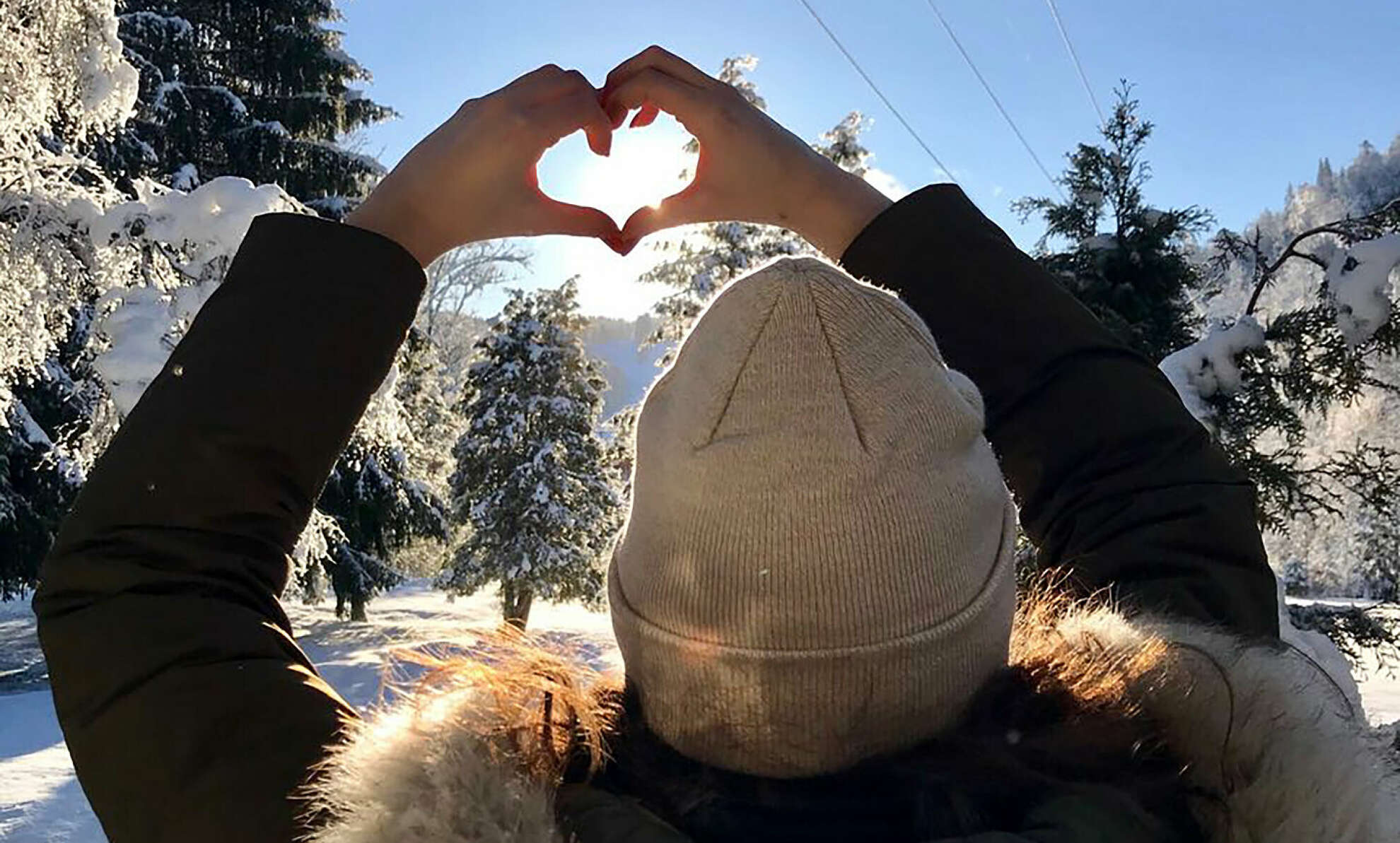 Die winterliche Sonne scheint durch das mit Händen gemacht Herz.