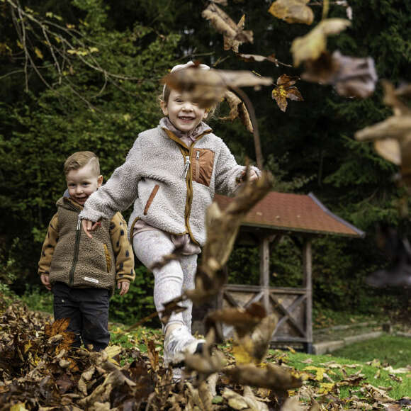 Kinderspaß in der Natur Kinder spielen mit Herbstlaub im Oberstaufen PARK