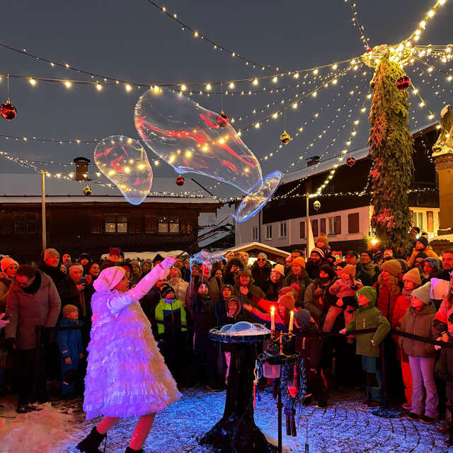 Seifeblasenshow bei Nacht Seifenblasenshow auf dem beleuchteten Marienplatz während des Winterzaubers in Oberstaufen.