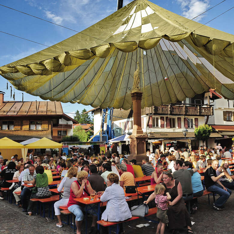 Besucher sitzen auf dem Martkfest in Oberstaufen