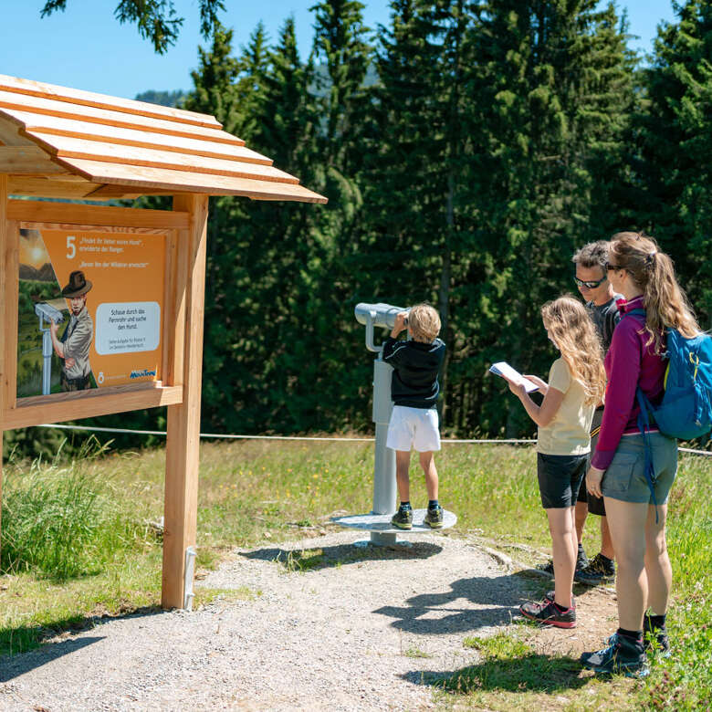 Familie an Station 5 auf dem MounTeens Detektivweg am Hündle