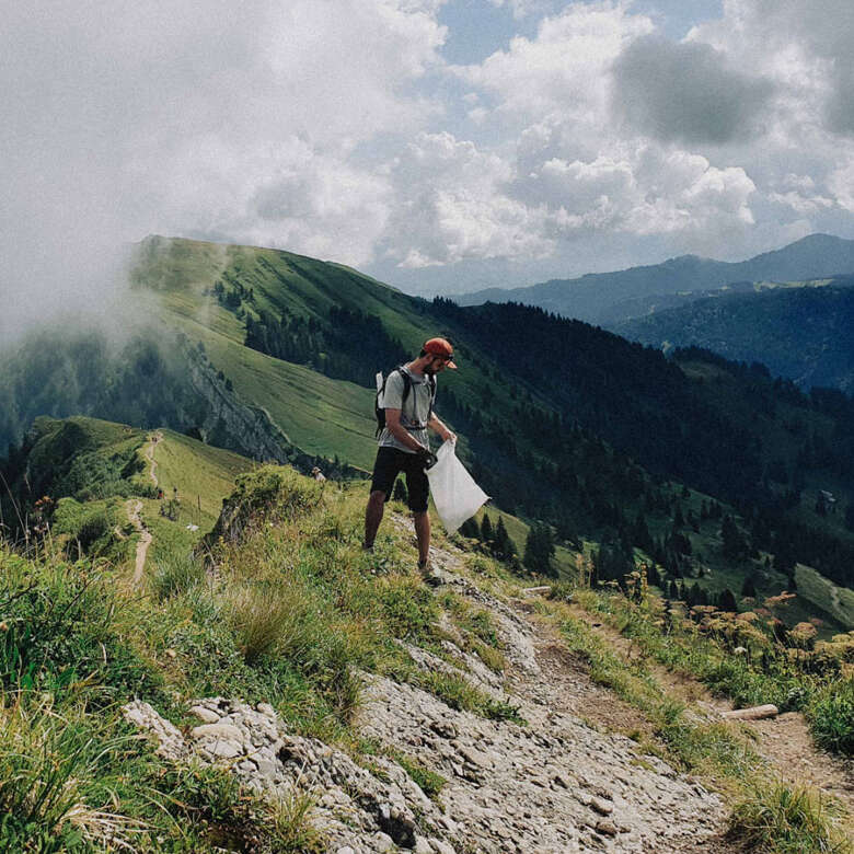 Allgäuer CleanUP Nagelfluhkette Mann sammelt Müll beim Wandern im Naturpark.