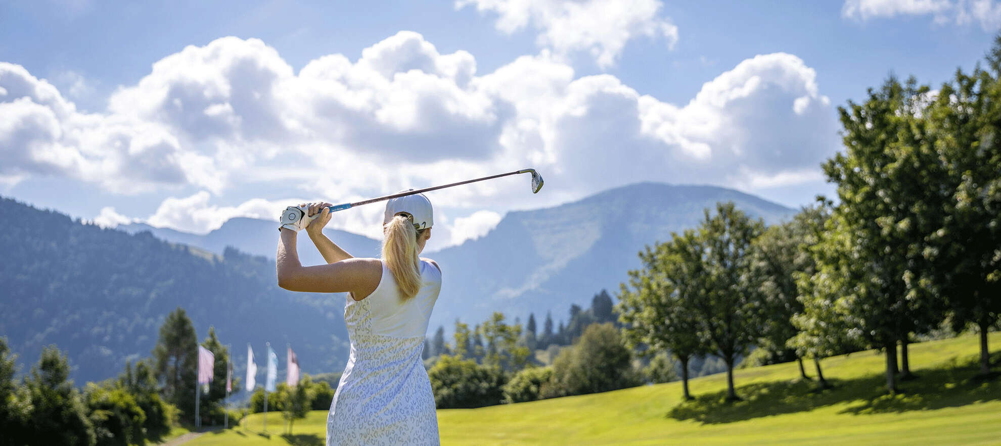 Frau spielt Golf mit Bergblick bei Oberstaufen Frau spielt Golf mit Bergblick bei Oberstaufen