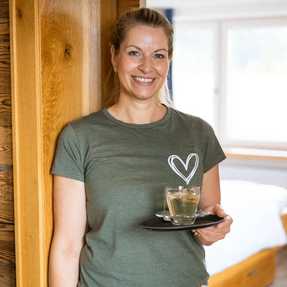 Andrea serviert ihren Gästen eine Tasse Tee ans Bett bevor sie die Schroth-Packung anlegt