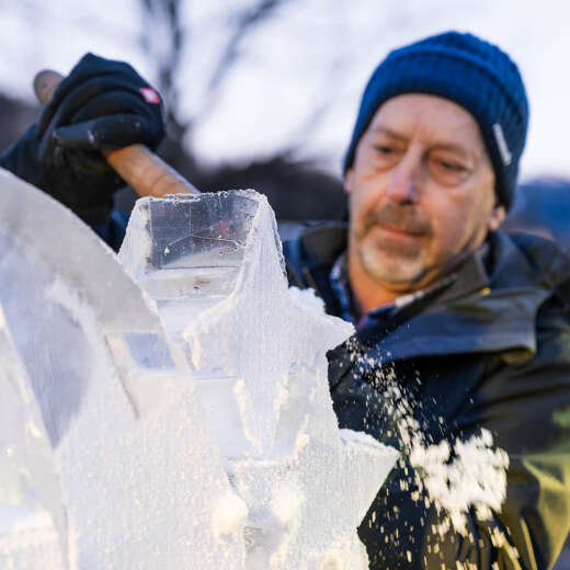 Mann schnitzt Eisskulptur im Allgäu