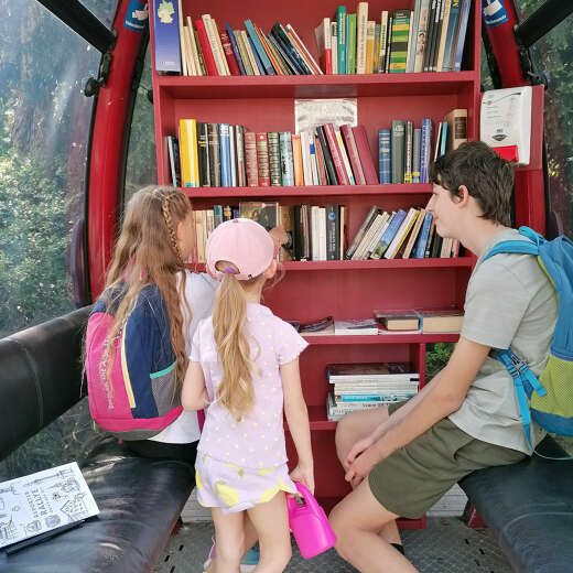 Kinder in Gondel mit Bücherregal