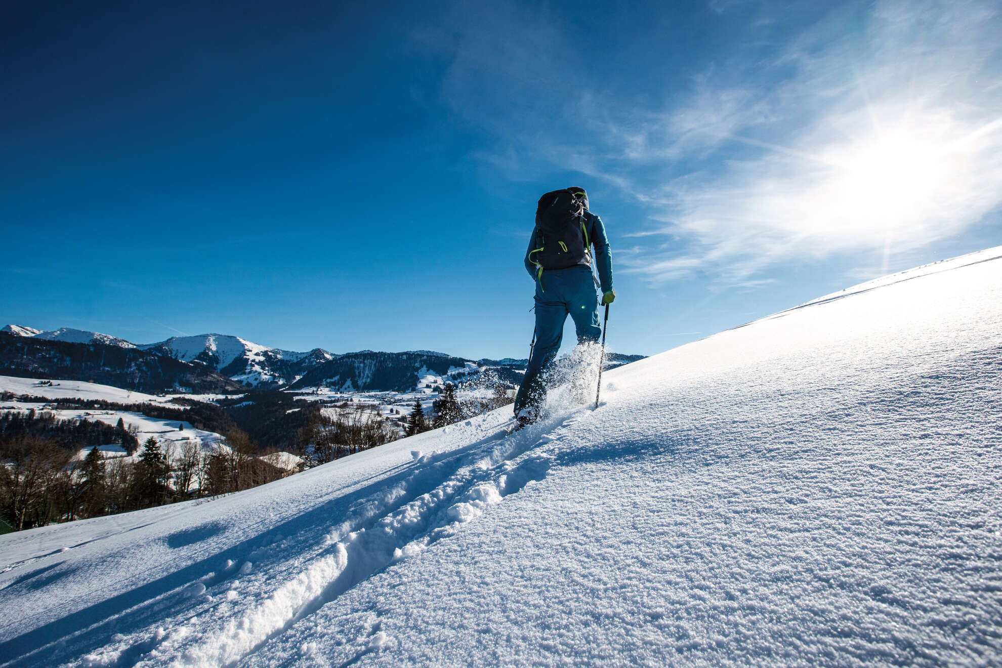 Mann wandert durch den Schnee im Naturpark Nagelfluhkette.