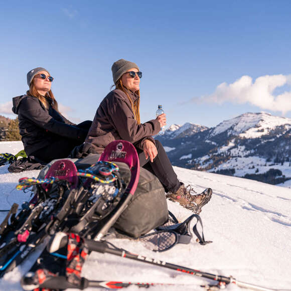 Auszeit beim Schneeschuhwandern Pause mit Bergblick beim Schneeschuhwandern