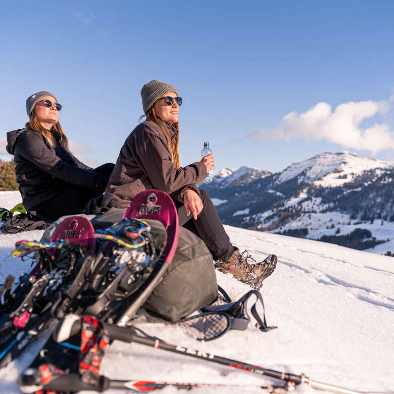 Auszeit beim Schneeschuhwandern Pause mit Bergblick beim Schneeschuhwandern