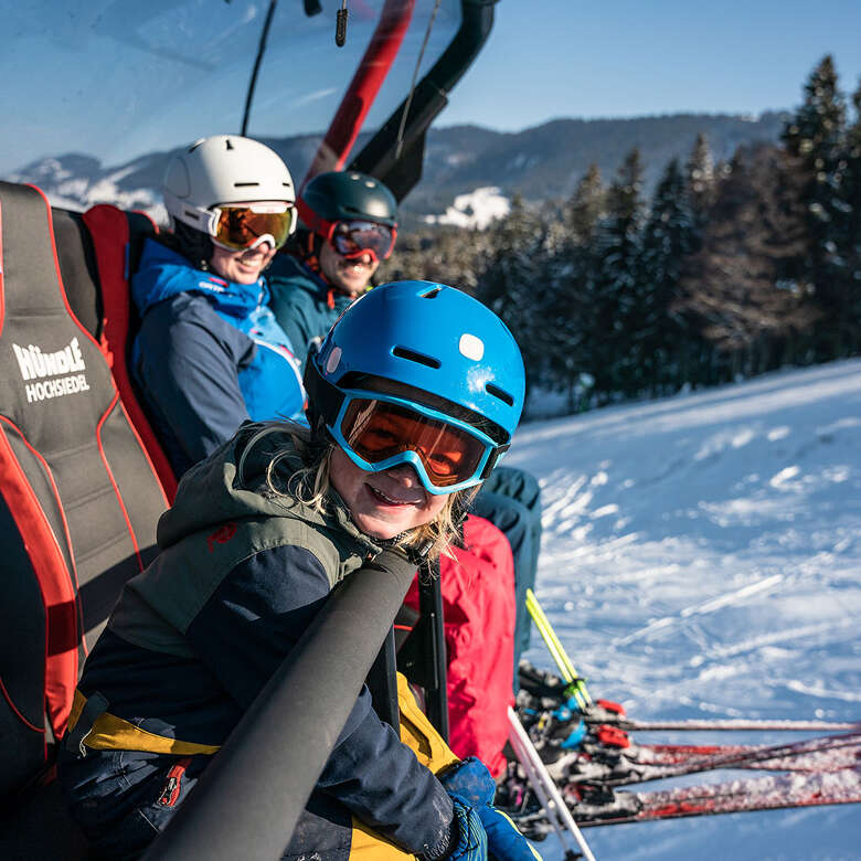 Familie beim Skifahren an der Hochsiedel-Sesselbahn im Hündle-Skigebiet.