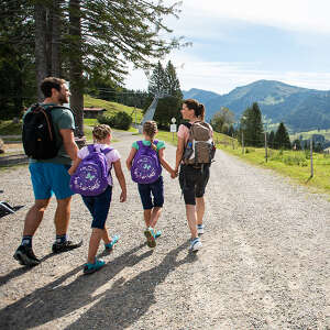 Eine Familie wandern auf einem Wanderweg mit Bergpanorama.