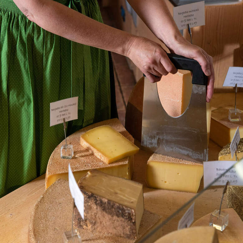 Frau schneidet Allgäuer Käse