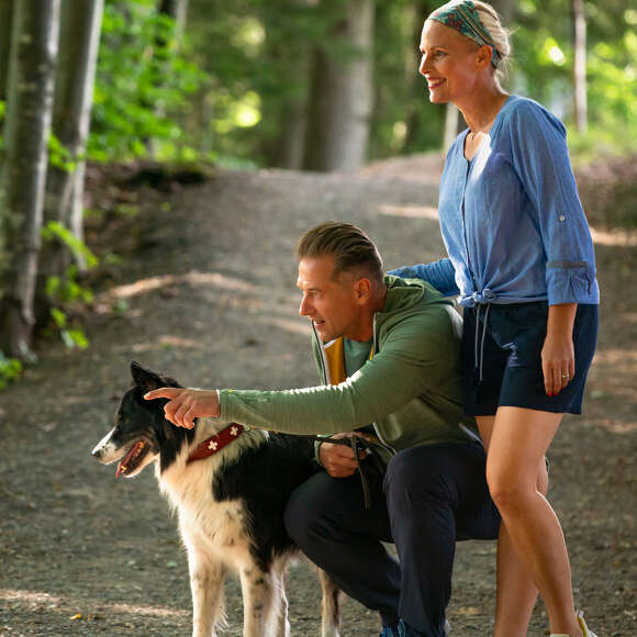 Paar mit Hund auf einem Wanderweg in Oberstaufen.