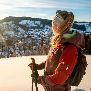 Frau blickt auf das verschneite Oberstaufen.